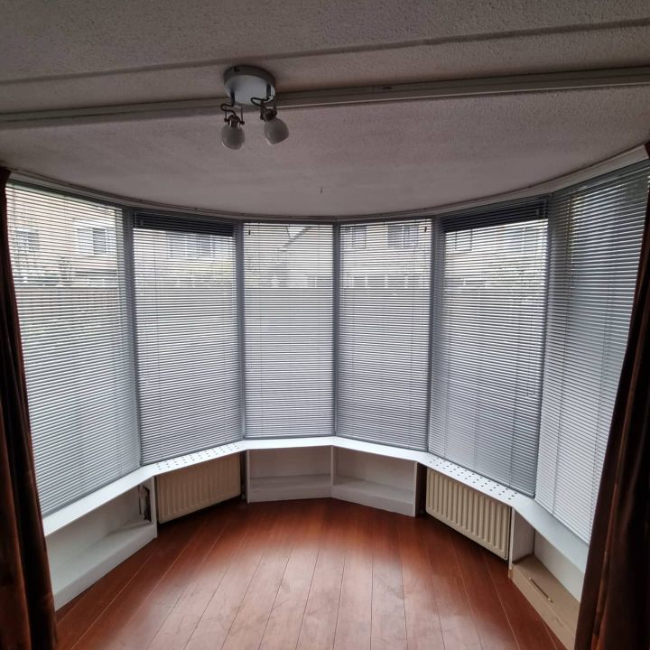 Houten jaloezieën in een erker van een jaren-30-woning in Hilversum-Zuid