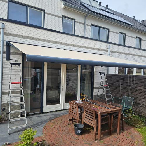 Zonnescherm in de tuin in de kleur beige in Huizen